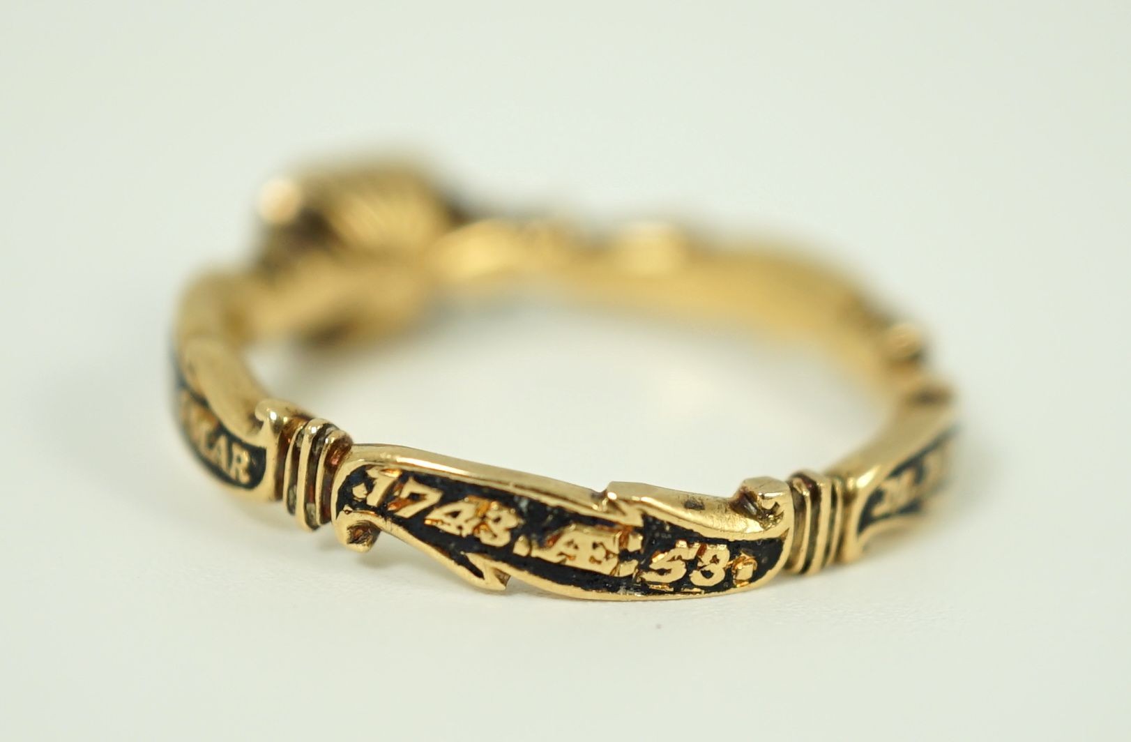 A George II gold, black enamel and rock crystal set mourning ring